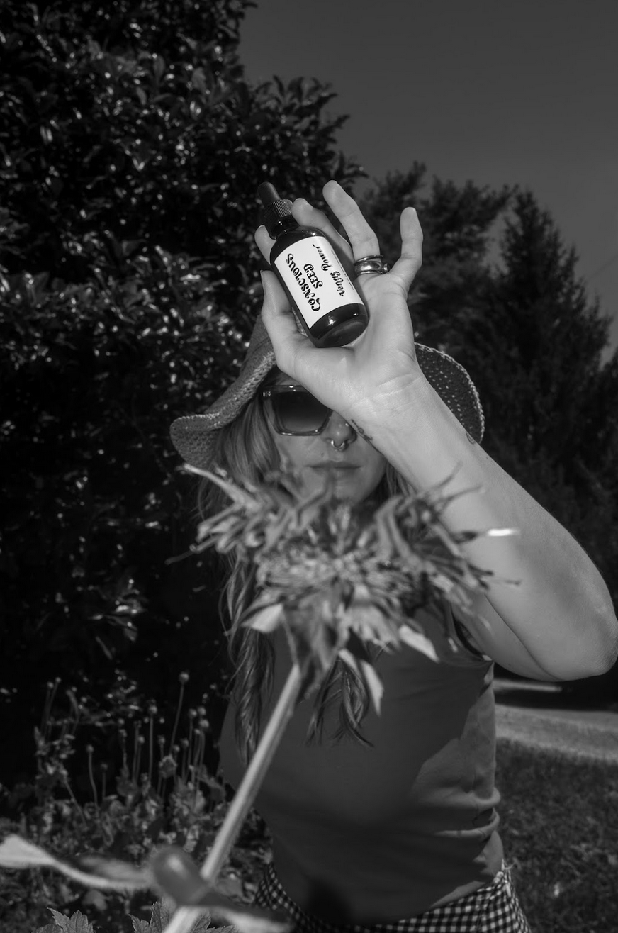 Person holding a bottle of Venus Power a herbal bitters made with flowers