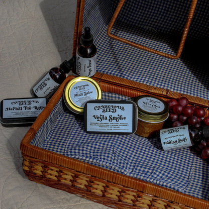 outdoors on a picnic-style setup with fruits and herbal remedies.