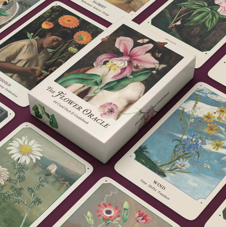 A box of 'The Flower Oracle' card deck displayed alongside its cards, featuring floral designs and vintage botanical illustrations.